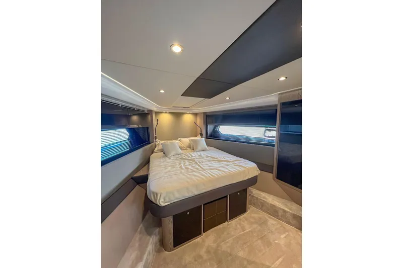 Yacht Photos Pics Luxurious bedroom interior of 2024 Azimut Atlantis 51 yacht, featuring modern design and cozy bedding.