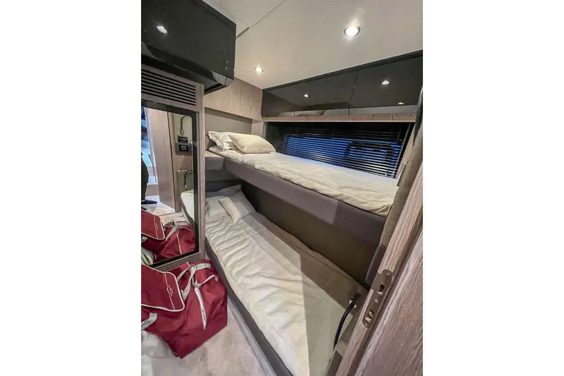 Yacht Photos Pics 2024 Azimut Atlantis 51 yacht interior with bunk beds and red duffel bags.