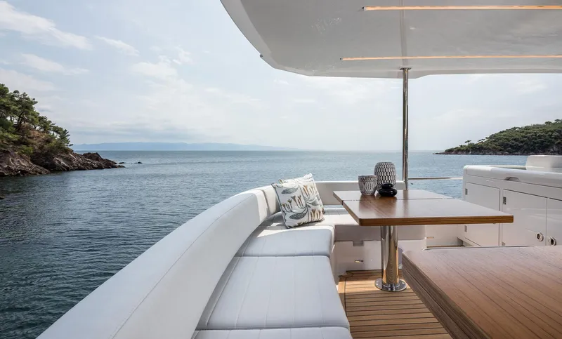 Yacht Photos Pics Luxurious Sirena 48 yacht deck with ocean view, featuring elegant seating and a wooden table, 2025 model.
