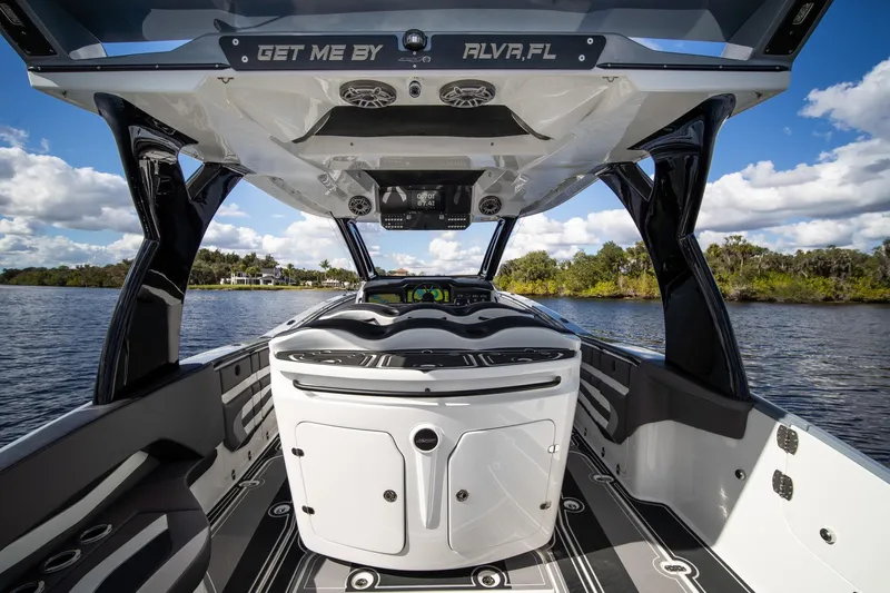  Yacht Photos Pics Luxury MTI V42 boat interior with sleek design, on a scenic waterway, under a blue sky.