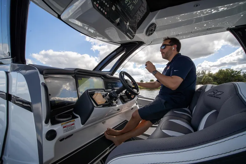  Yacht Photos Pics Man piloting 2020 MTI V42 boat under clear sky.