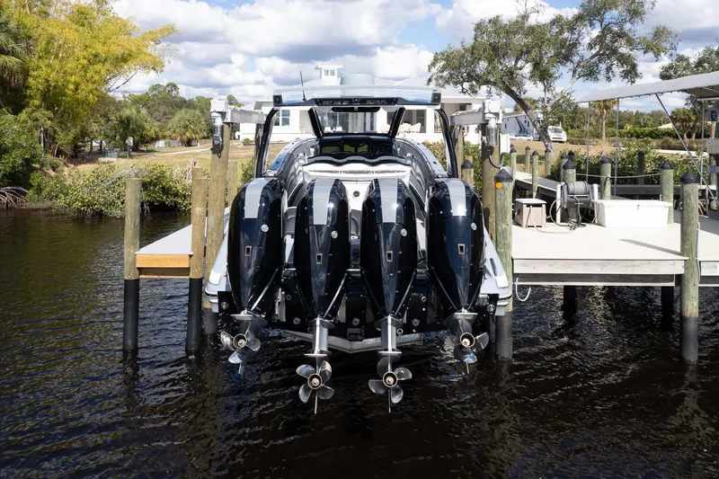  Yacht Photos Pics 2020 MTI V42 boat with four powerful outboard engines docked by a scenic waterfront.