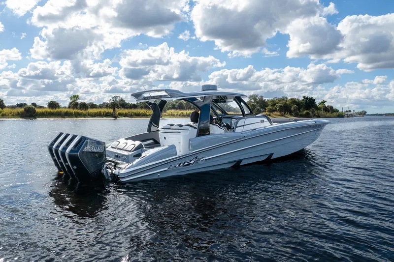  Yacht Photos Pics 2020 MTI V42 boat on a calm lake under a cloudy sky.