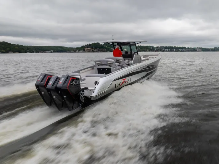  Yacht Photos Pics 2025 Donzi 39 VRZ speedboat cruising on a lake with triple outboard engines.