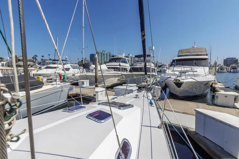 Blue Moon Yacht Photos Pics Catalina 400 MkII sailboat docked in a marina, surrounded by other boats, under clear blue sky.