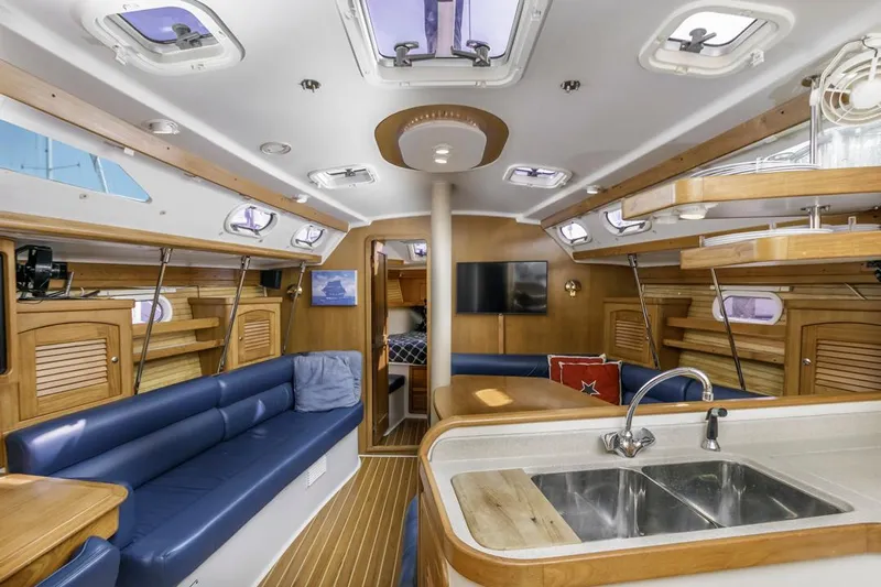 Blue Moon Yacht Photos Pics Interior of 2004 Catalina 400 MkII yacht with blue seating, wood accents, and modern amenities.