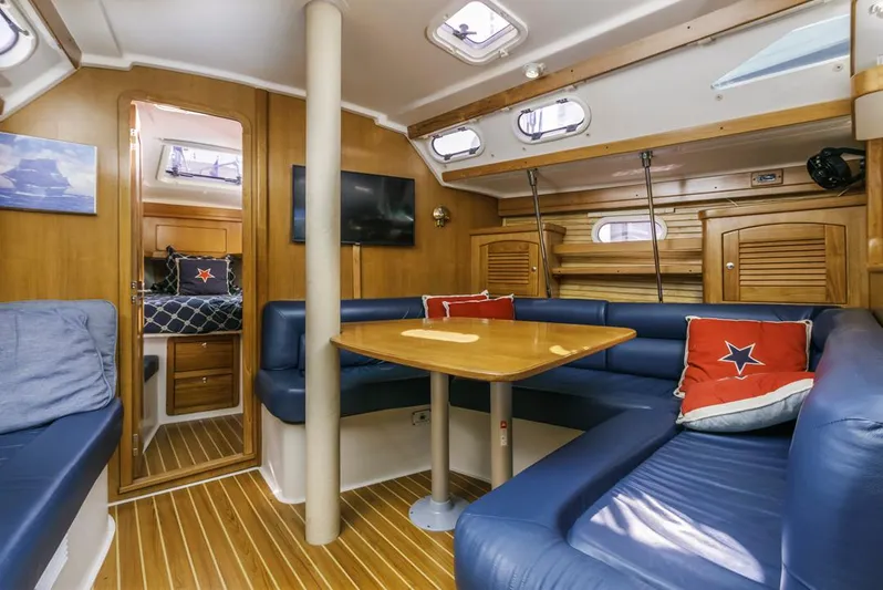 Blue Moon Yacht Photos Pics Interior of 2004 Catalina 400 MkII sailboat with blue seating and wooden accents.