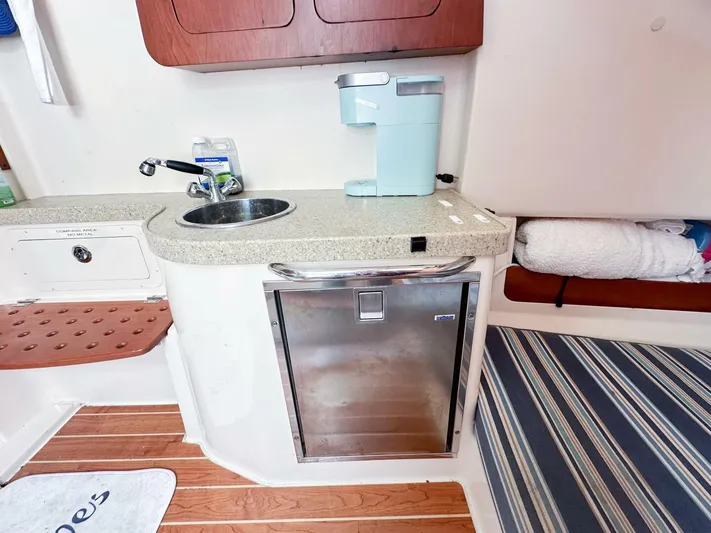  Yacht Photos Pics Compact kitchenette in 2011 Grady-White 366 Canyon boat with sink, mini-fridge, and coffee maker.