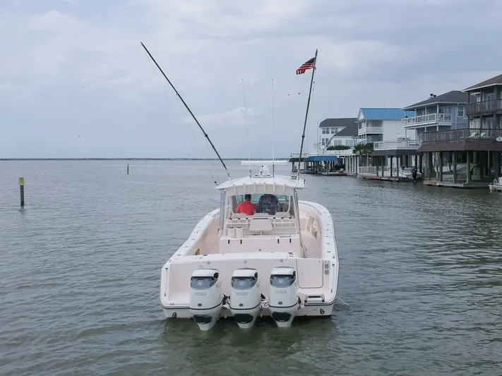  Yacht Photos Pics Grady-White 366 Canyon boat with 2020 Suzuki engines on a calm waterfront.