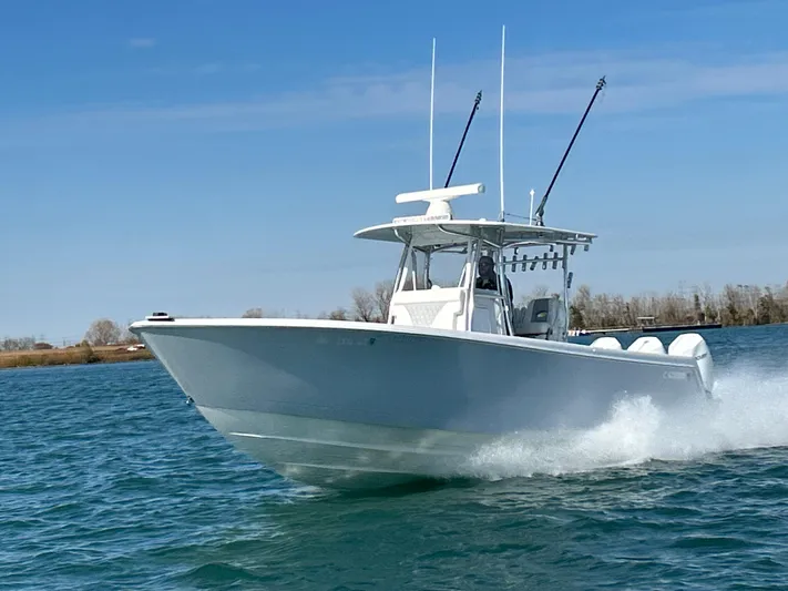  Yacht Photos Pics 2022 Contender 35 ST boat cruising on open water, clear sky background.