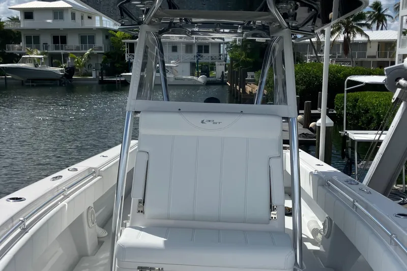  Yacht Photos Pics 2016 Contender 30 ST boat interior with white seating, docked near waterfront homes.