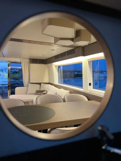  Yacht Photos Pics Interior view of 2023 Azimut Magellano 66 yacht through a circular window.