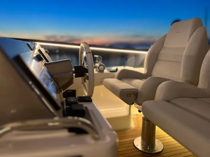  Yacht Photos Pics Helm of 2023 Azimut Magellano 66 yacht at sunset, featuring modern controls and seating.
