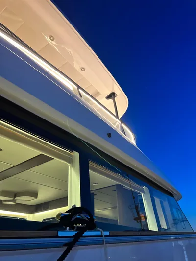  Yacht Photos Pics Azimut Magellano 66 yacht, 2023 model, illuminated against a deep blue evening sky.