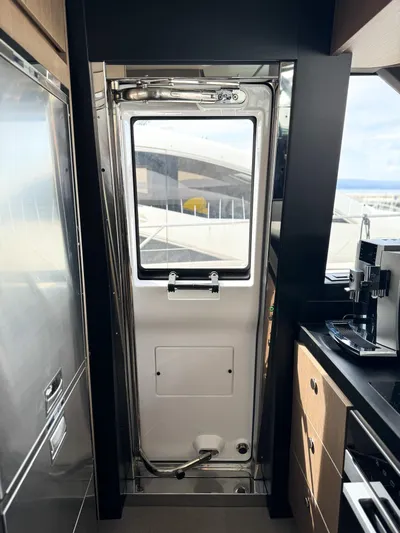 Yacht Photos Pics Interior view of 2023 Azimut Magellano 66 yacht, featuring a sleek kitchen and door.