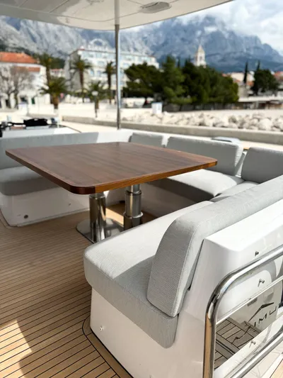  Yacht Photos Pics Luxury seating area on 2023 Azimut Magellano 66 yacht with scenic coastal backdrop.