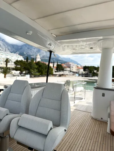  Yacht Photos Pics Luxury Azimut Magellano 66 yacht interior, 2023 model, featuring plush seating and scenic coastal view.
