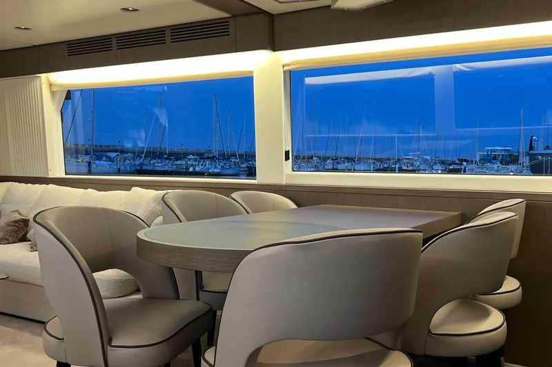  Yacht Photos Pics Luxurious dining area inside 2023 Azimut Magellano 66 yacht with marina view.