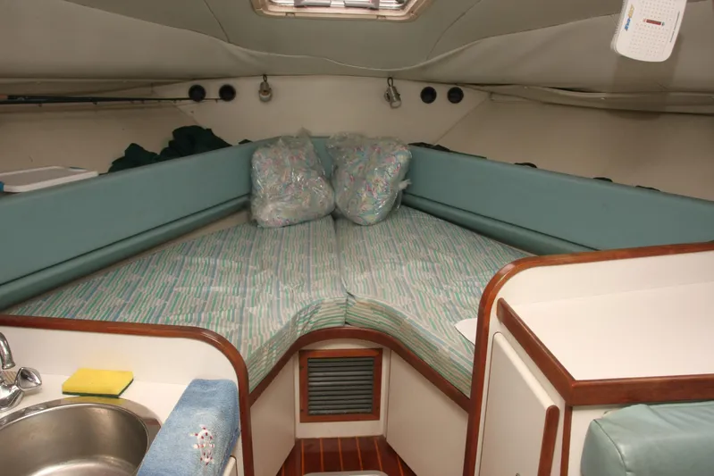  Yacht Photos Pics Cozy cabin interior of 2017 Osprey 30 Fisherman boat with cushioned seating and compact sink.