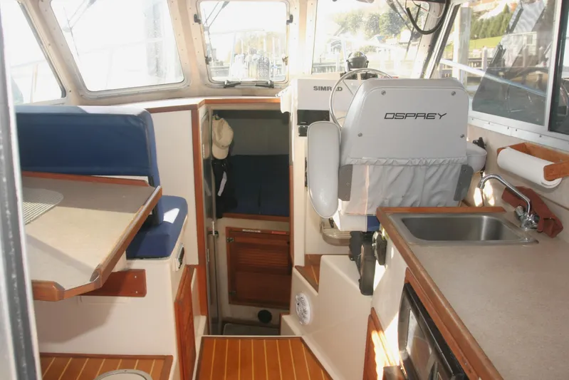  Yacht Photos Pics Interior of 2017 Osprey 30 Fisherman boat with seating, sink, and helm station.