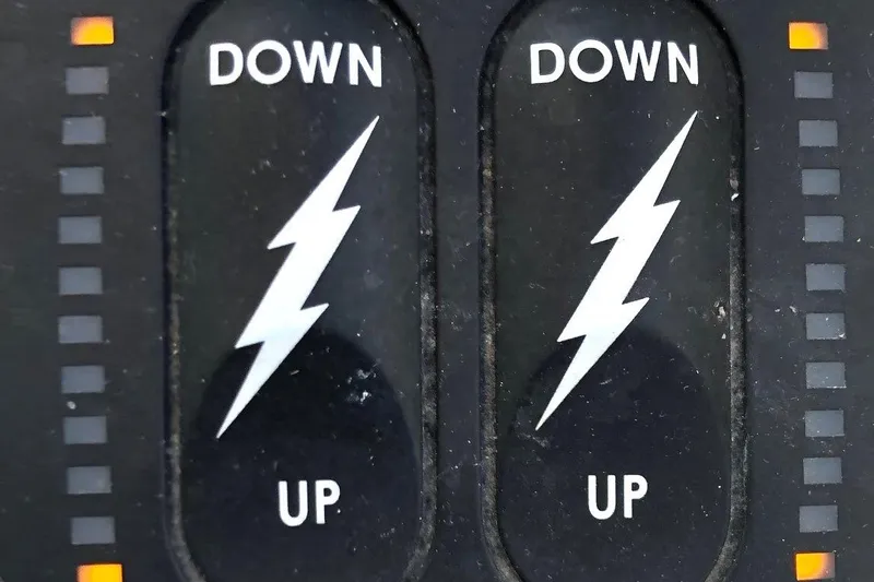  Yacht Photos Pics Close-up of Osprey 30 Fisherman 2017 control panel with lightning symbols and "UP" and "DOWN" labels.