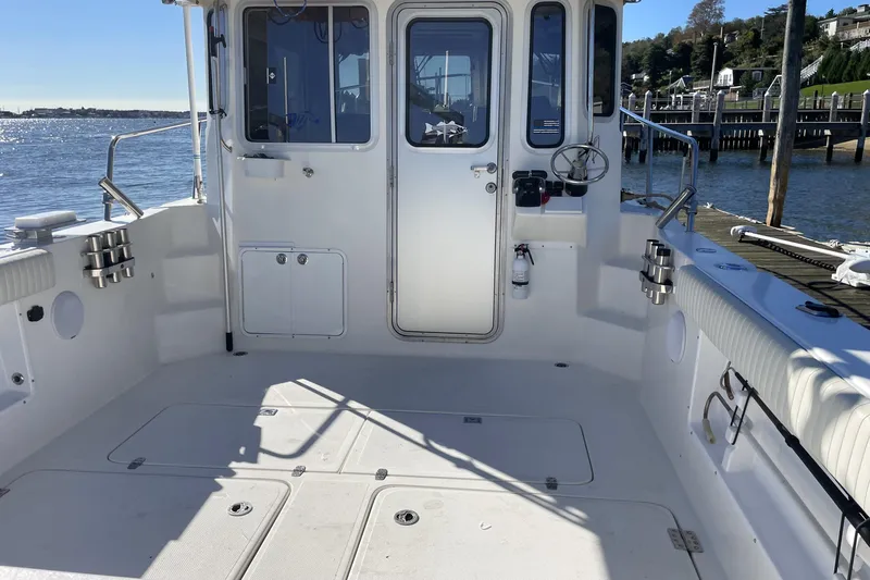  Yacht Photos Pics 2017 Osprey 30 Fisherman boat deck with fishing rod holders, docked by the water.