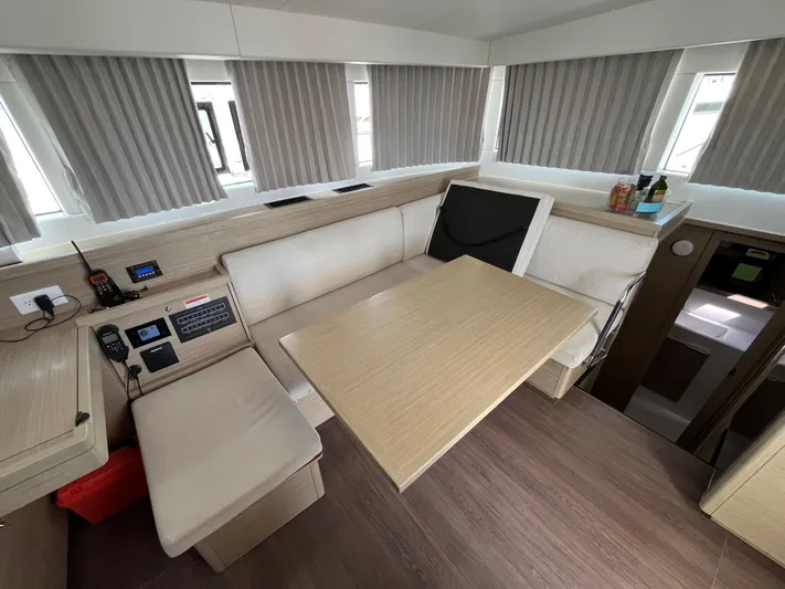  Yacht Photos Pics 2023 Lagoon 40 yacht interior with dining area, beige seating, and modern amenities.
