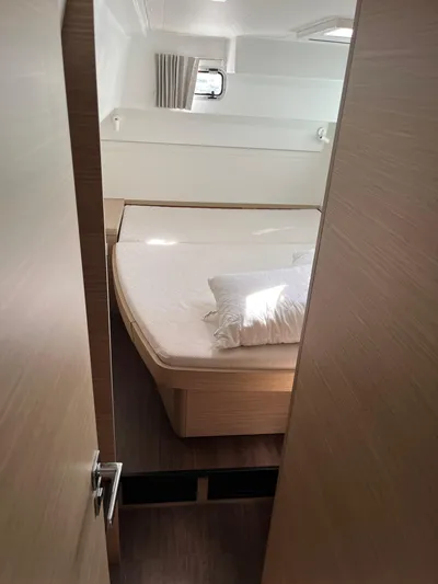  Yacht Photos Pics 2023 Lagoon 40 yacht cabin with bed, pillow, and window.
