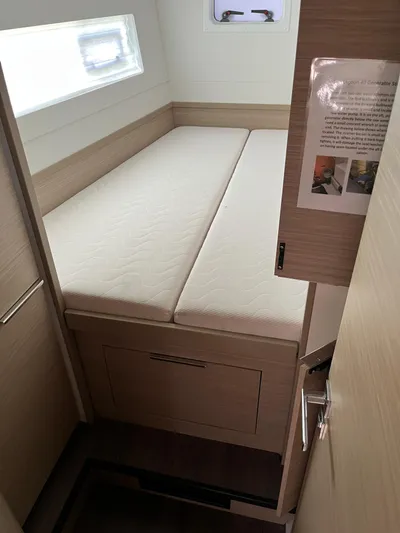  Yacht Photos Pics 2023 Lagoon 40 yacht cabin interior with bed and window.