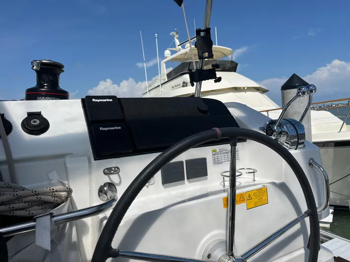  Yacht Photos Pics Helm of 2023 Lagoon 40 catamaran with navigation equipment, docked under clear blue sky.