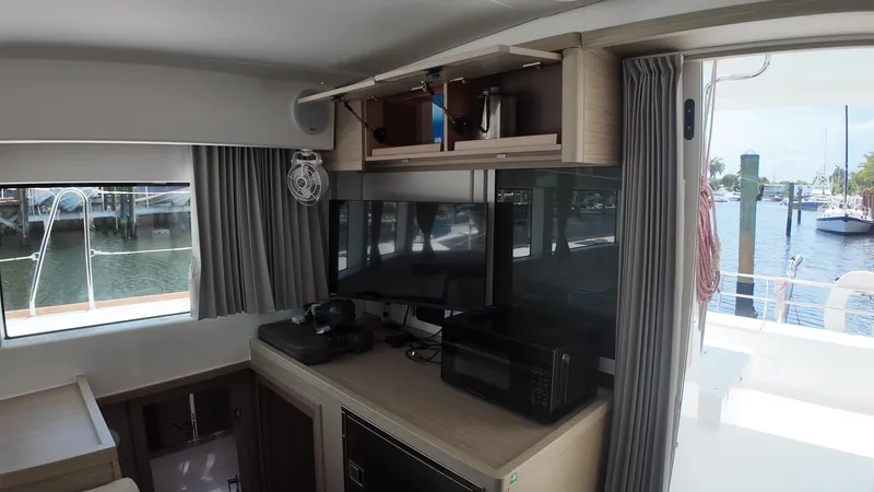  Yacht Photos Pics Interior of 2023 Lagoon 40 catamaran with modern kitchen and marina view.