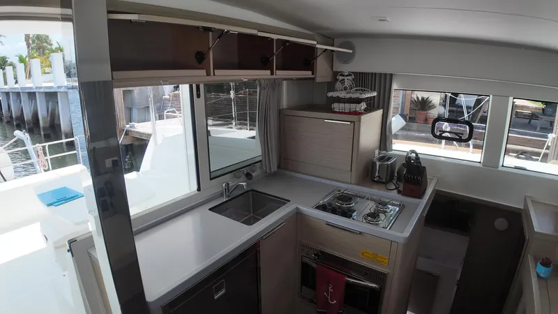  Yacht Photos Pics Modern kitchen interior of 2023 Lagoon 40 catamaran with stove, sink, and ample storage.
