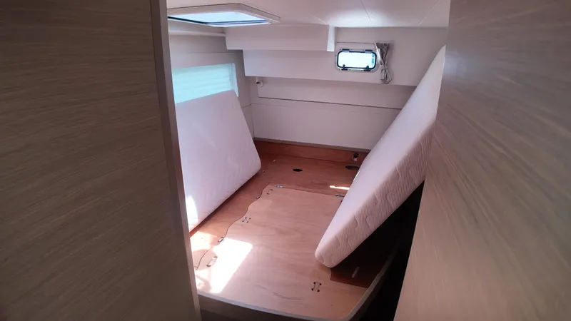  Yacht Photos Pics 2023 Lagoon 40 yacht interior cabin with mattress and wooden flooring.