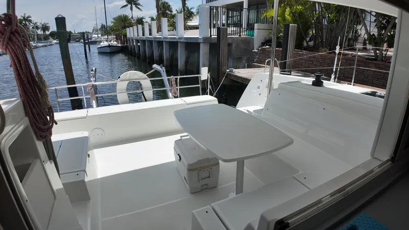  Yacht Photos Pics 2023 Lagoon 40 catamaran cockpit with seating and table, docked at a marina.