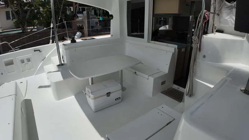  Yacht Photos Pics 2023 Lagoon 40 catamaran cockpit with seating, table, and cooler.