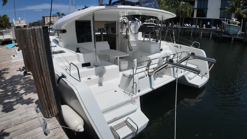  Yacht Photos Pics 2023 Lagoon 40 catamaran docked at a marina, showcasing its sleek design and spacious deck.