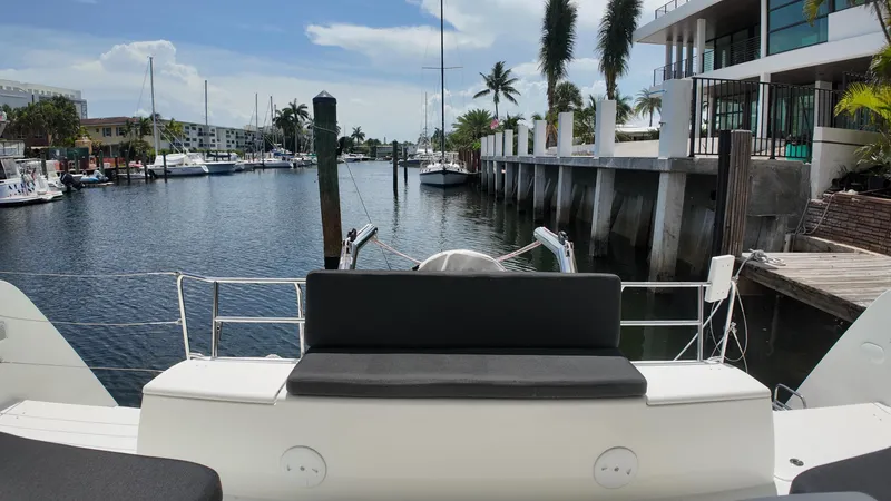  Yacht Photos Pics 2023 Lagoon 40 yacht docked in a scenic marina with palm trees.