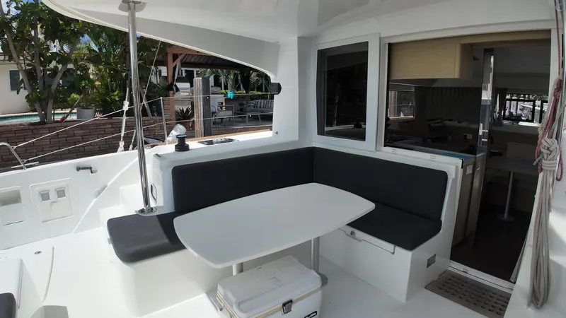  Yacht Photos Pics 2023 Lagoon 40 catamaran cockpit with seating and table, showcasing modern design and comfort.