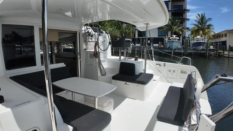  Yacht Photos Pics 2023 Lagoon 40 catamaran cockpit with seating, table, and marina view.