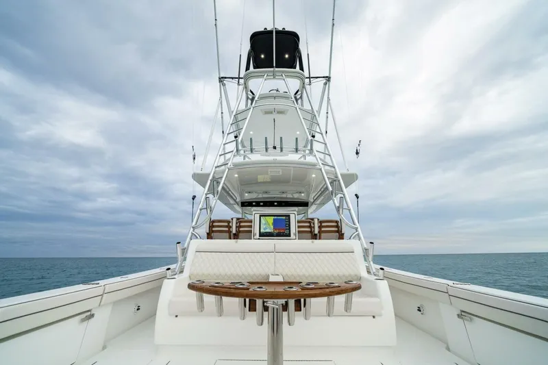  Yacht Photos Pics 2024 Valhalla Boatworks V-55 yacht with tower, ocean backdrop, and fishing equipment.