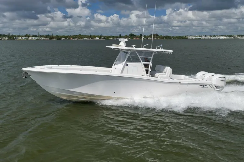  Yacht Photos Pics 2018 Invincible 36' Open Fisherman boat cruising on water under cloudy sky.