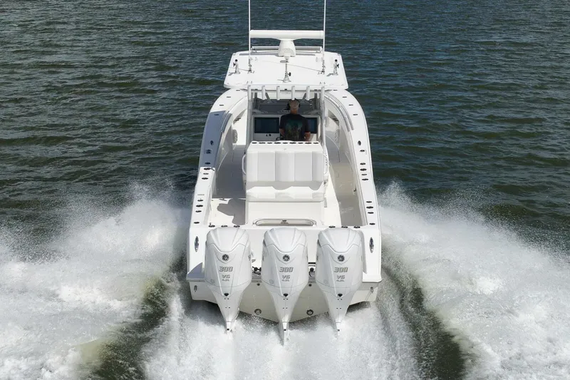  Yacht Photos Pics 2018 Invincible 36' Open Fisherman boat cruising on water, rear view.