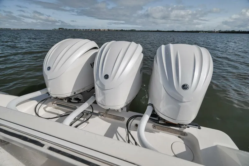  Yacht Photos Pics Triple outboard engines on a 2018 Invincible 36' Open Fisherman boat, on calm waters.