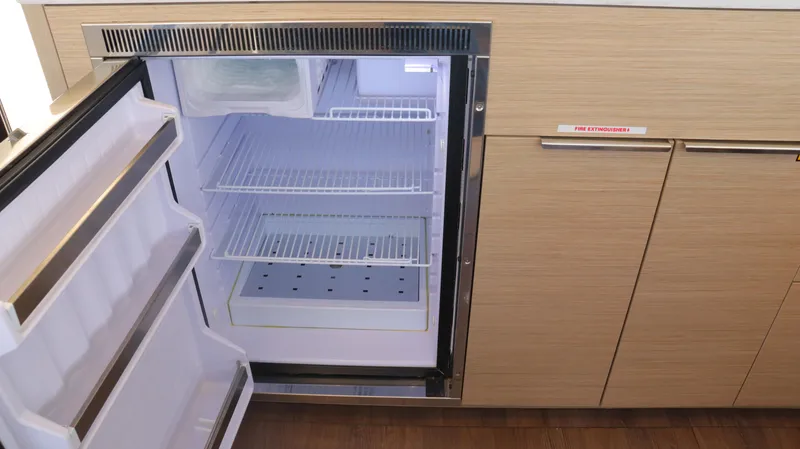 Happy Fluke Yacht Photos Pics Open refrigerator in 2023 Lagoon 46 yacht kitchen, showcasing modern design and storage space.