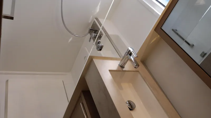 Happy Fluke Yacht Photos Pics Modern bathroom interior of 2023 Lagoon 46 yacht, featuring sleek sink and shower design.