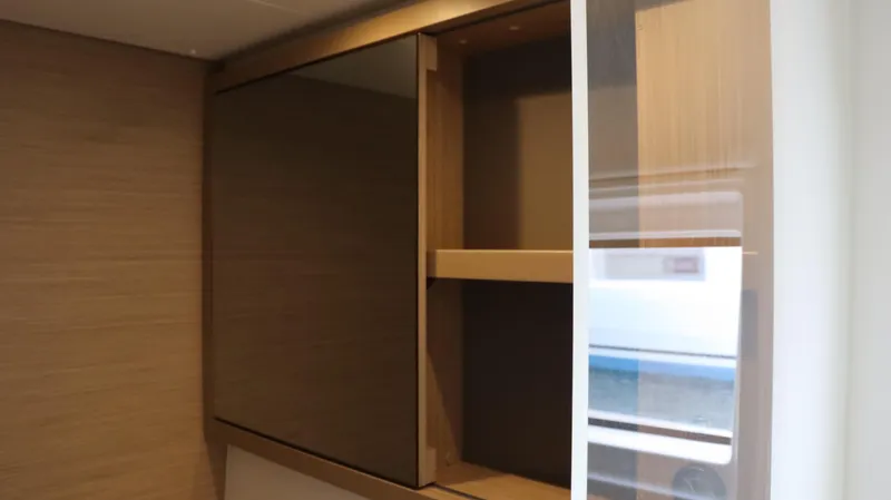 Happy Fluke Yacht Photos Pics Wooden cabinet interior on 2023 Lagoon 46 yacht, showcasing sleek design and ample storage.