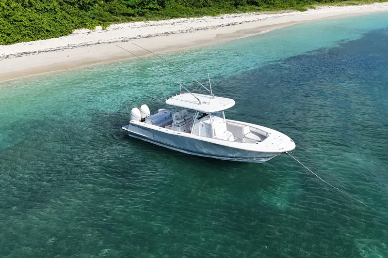  Yacht Photos Pics 2024 Southport 30 FE boat anchored near a sandy beach with clear turquoise water.