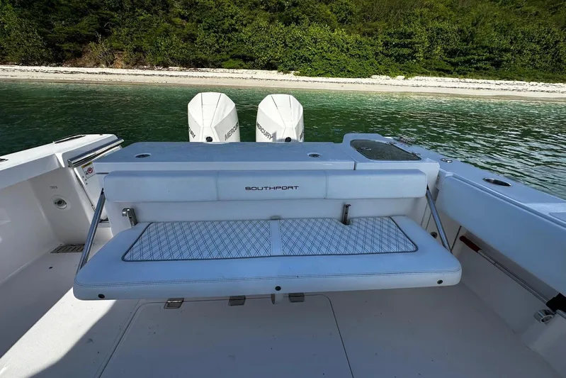  Yacht Photos Pics 2024 Southport 30 FE boat with dual Mercury engines, docked near a lush shoreline.