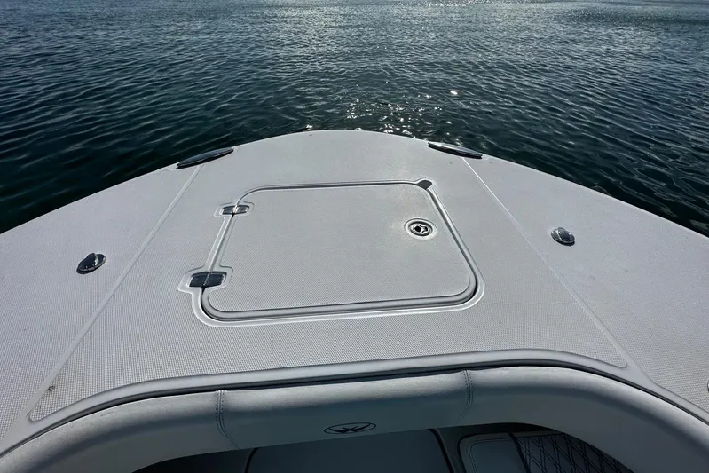  Yacht Photos Pics 2024 Southport 30 FE boat deck with storage hatch, on calm water.