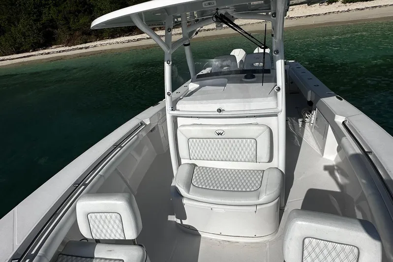  Yacht Photos Pics 2024 Southport 30 FE boat with white seating, docked near a sandy beach.